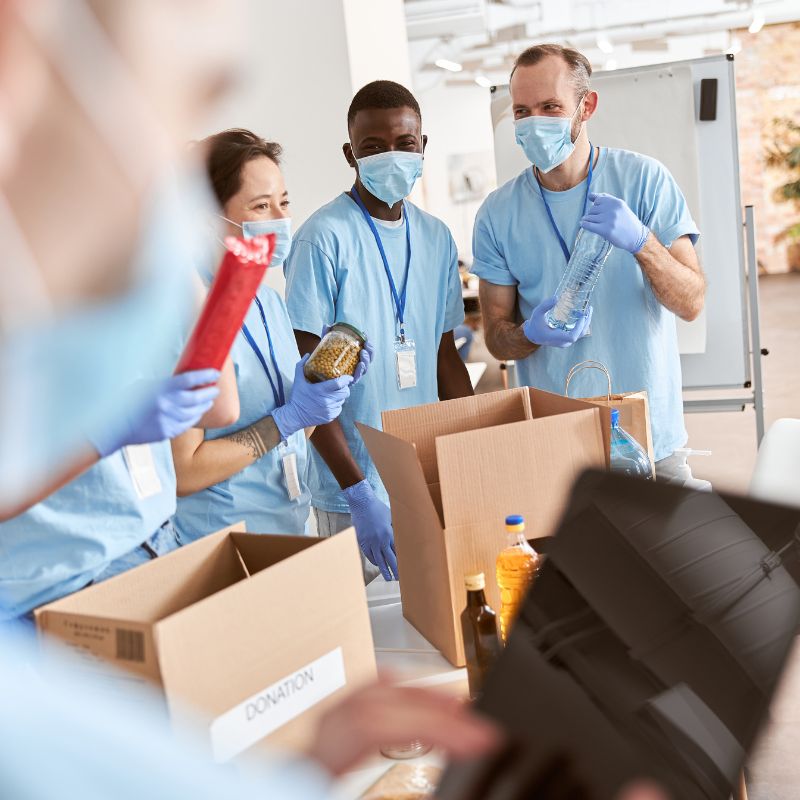 Personal institucional con equipo de protección manipulando insumos de higiene y limpieza distribuidos por CORPOMED en Guatemala